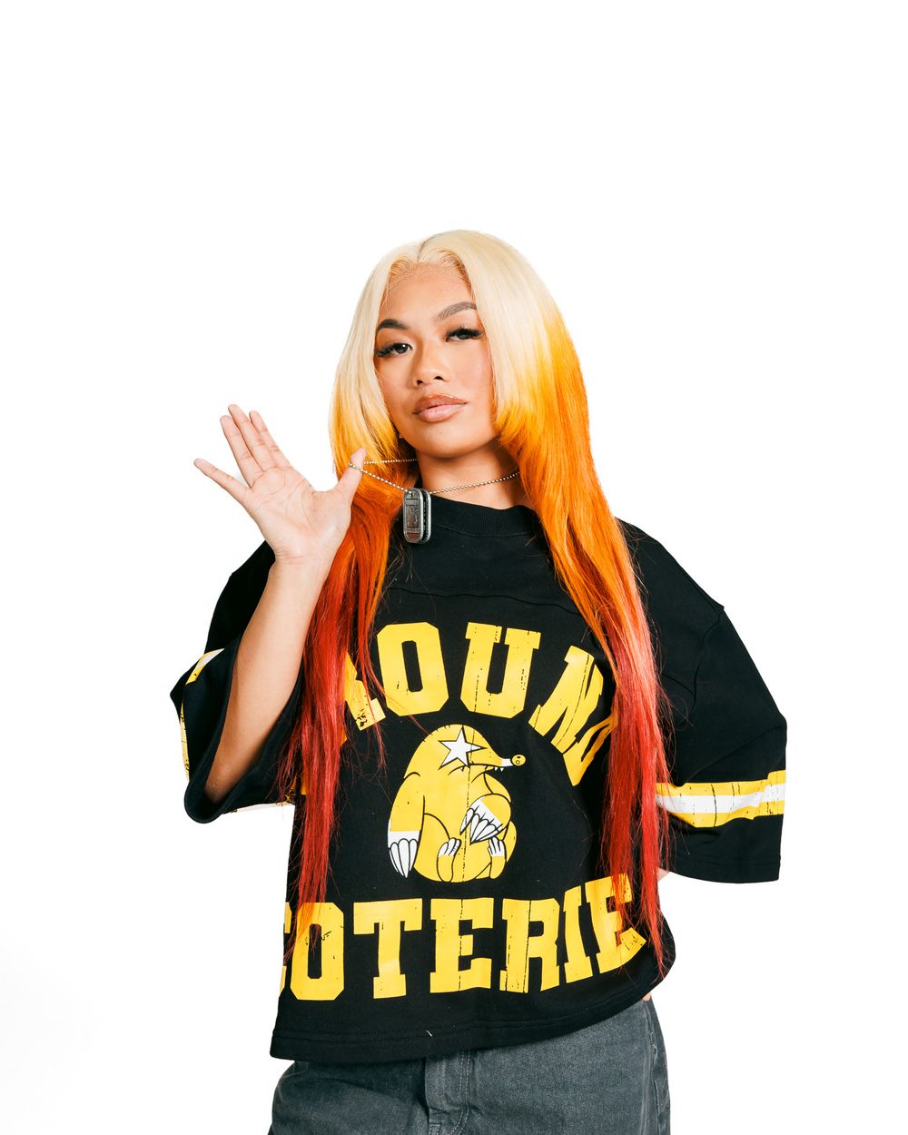 A person with blonde and orange ombre hair wearing a black Young Hoterie sports jersey with yellow text.