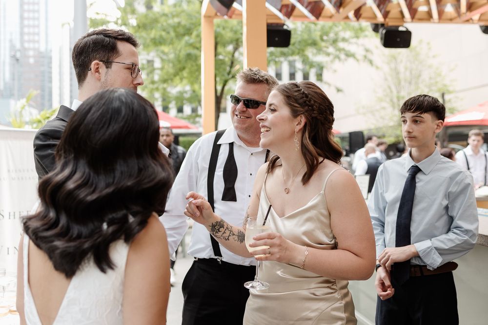 Wedding guests in formal attire socializing at Le Cathcart's terrace during cocktail hour in downtown Montreal