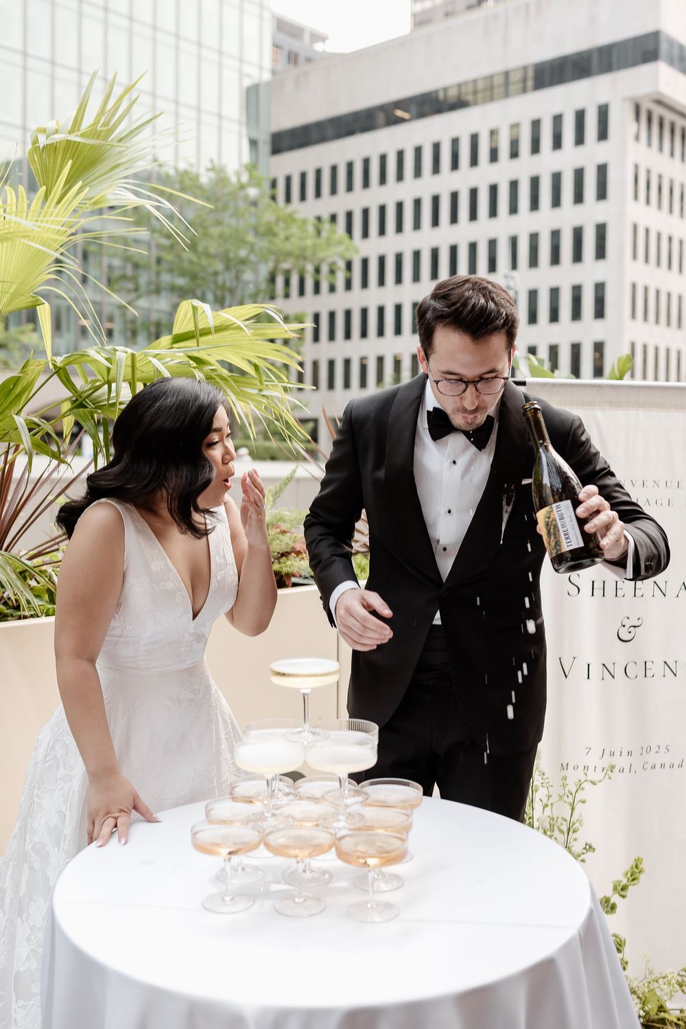 Groom pours champagne tower as bride watches in surprise as it spills at Le Cathcart in Montreal captured by Aliza Dworkind