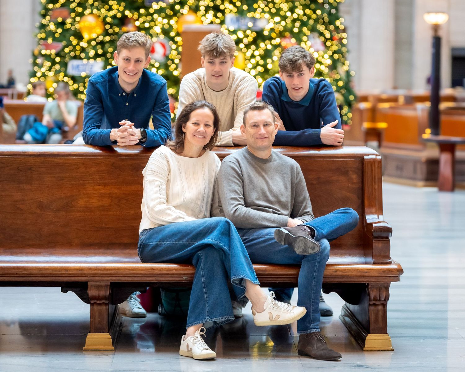 Family of five pose on a bench for a Christmas portrait