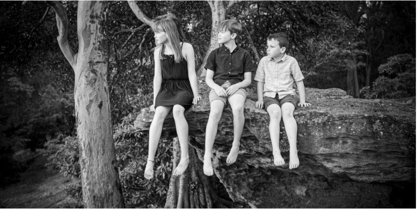 Group gathering for outdoor photos in a wooded setting during golden hour.