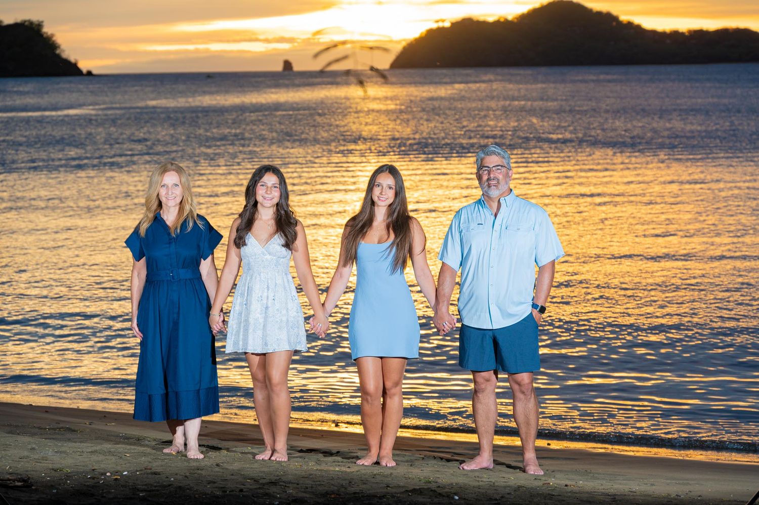 Family of five posing in elegant white outfits in a warmly lit hotel Waldorf Astoria