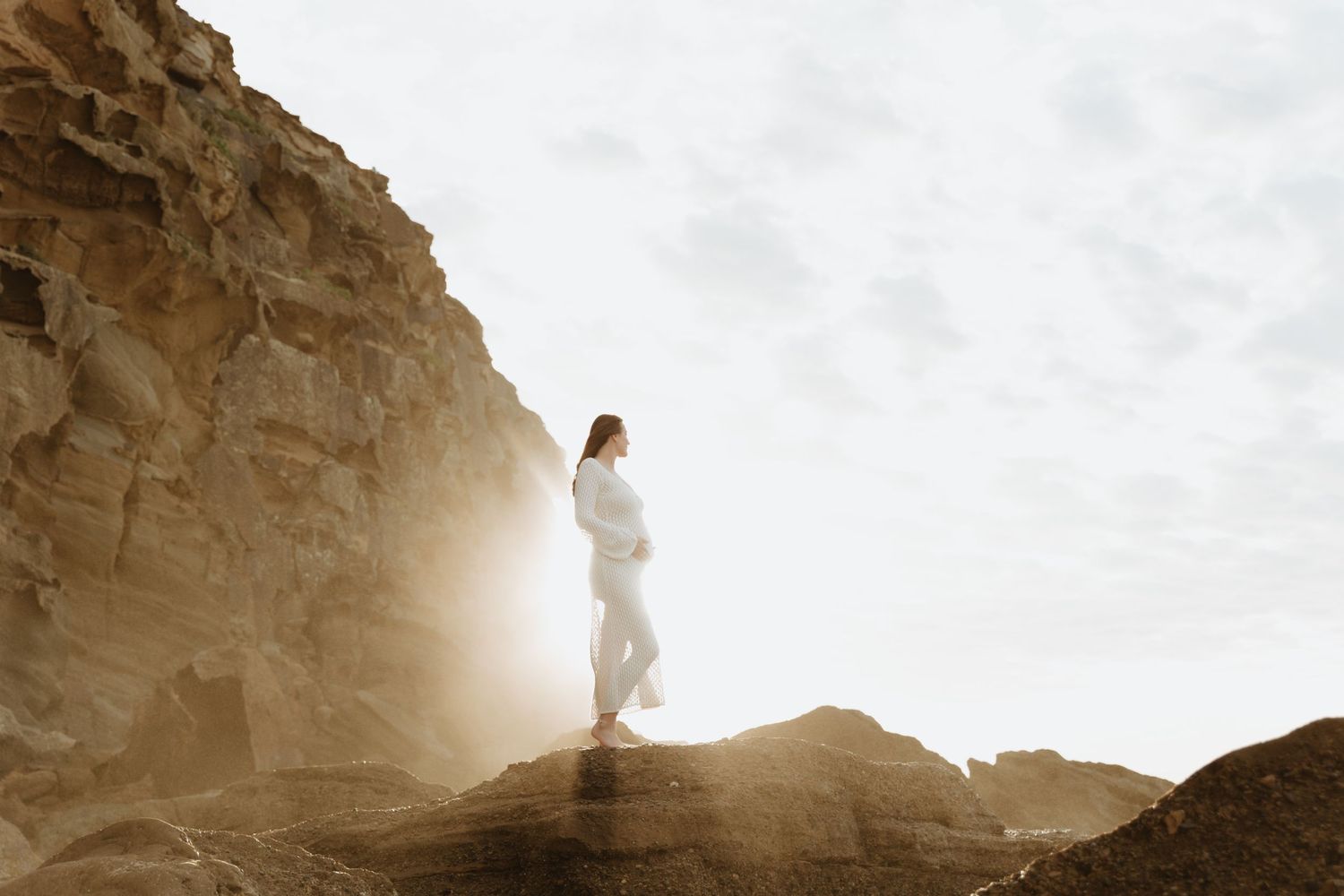 Pregnancy photoshoot on the rocks at a beach in Lake Macquarie NSW. Photo taken at sunrise.