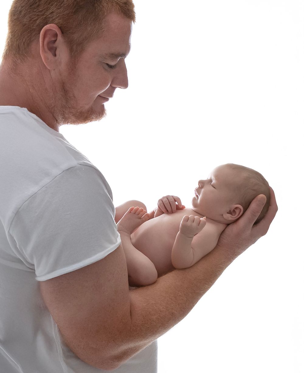 newborn baby girl with parents soft light Lakewood ranch family studio portrait emotional connection natural calm moment