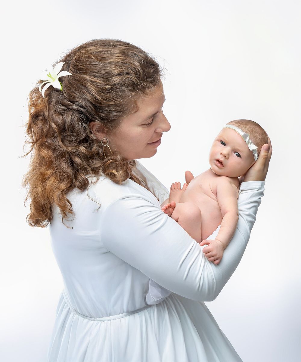 newborn baby girl with parents soft light Lakewood ranch family studio portrait emotional connection natural calm moment