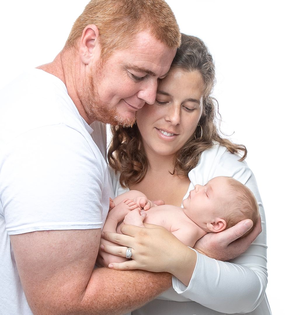 newborn baby girl with parents soft light Lakewood ranch family studio portrait emotional connection natural calm moment