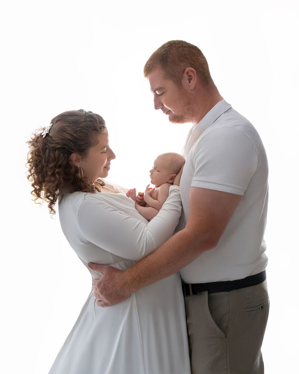 newborn baby girl with parents soft light Lakewood ranch family studio portrait emotional connection natural calm moment