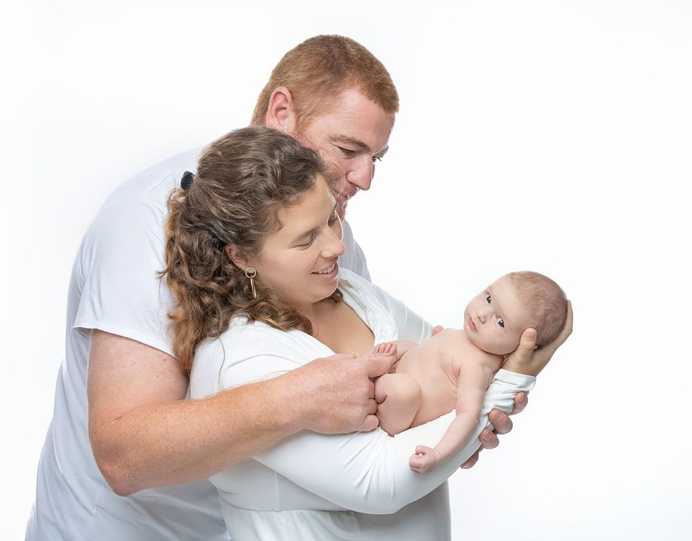 newborn baby girl with parents soft light Lakewood ranch family studio portrait emotional connection natural calm moment