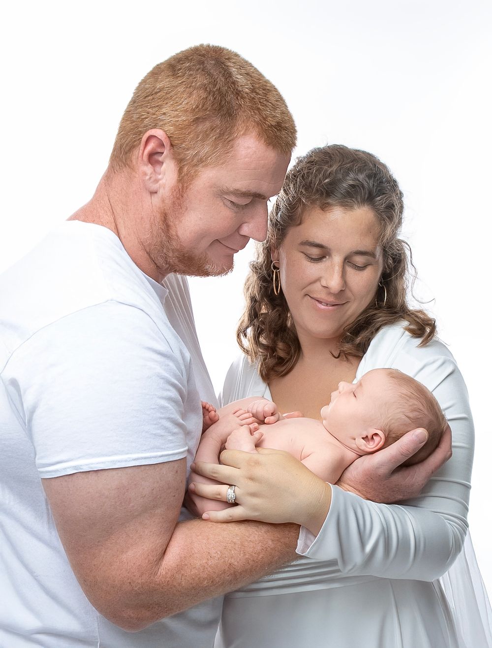 newborn baby girl with parents soft light Lakewood ranch family studio portrait emotional connection natural calm moment