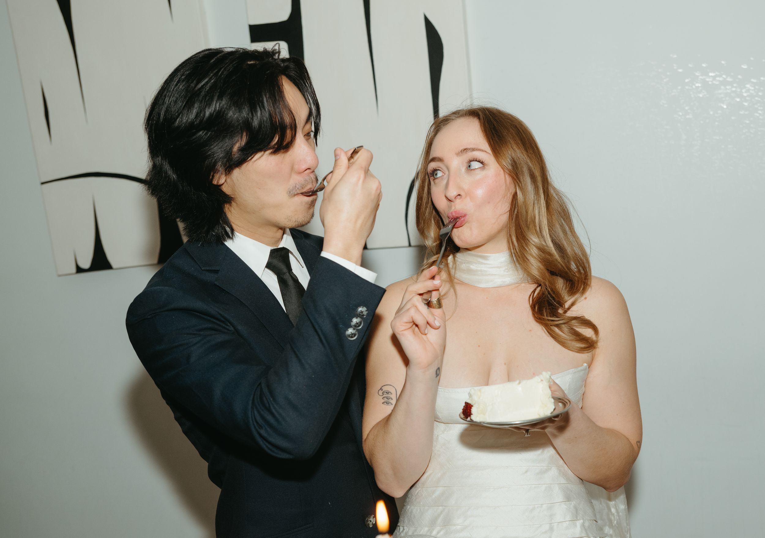 Couple sharing cake during a wedding reception photographed by Hannah Decossas Photography