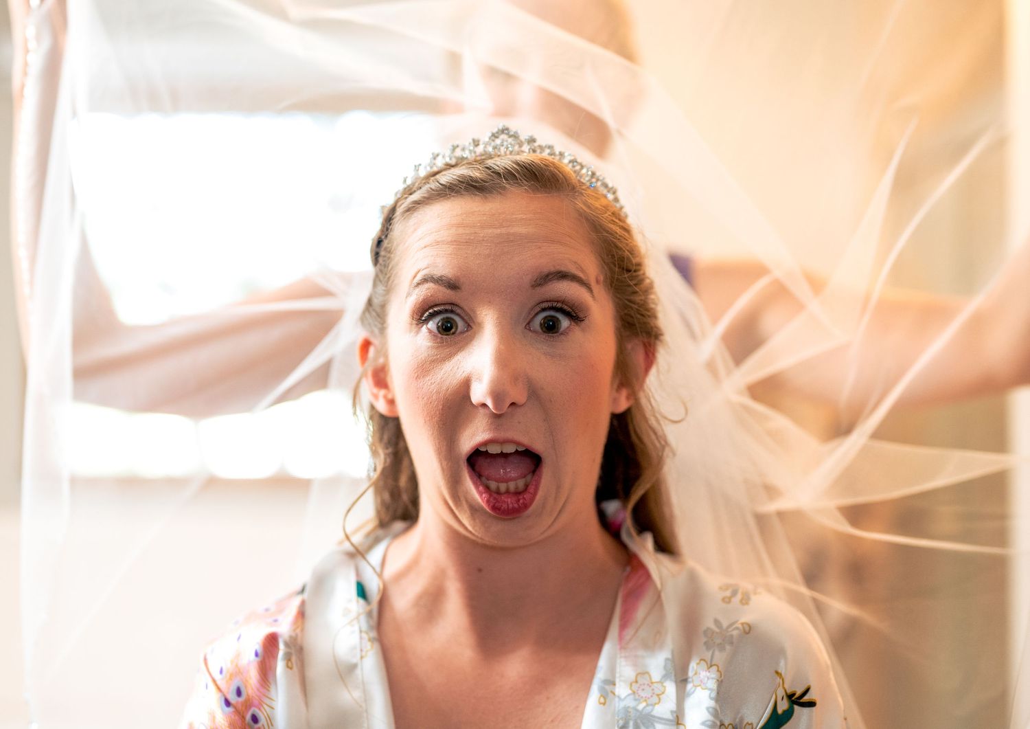 Bride wearing veil shows playful expressions in series of close-up wedding portraits.