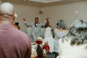 Bride and groom make grand reception entrance to cheering guests.