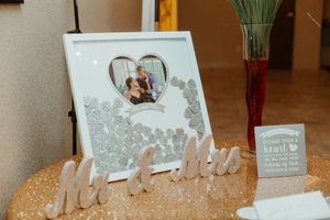 Wedding guest book frame with couple photo, Mr and Mrs wooden letters on gold sequin table.