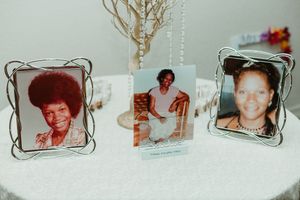 Three framed memorial photos displayed on glittery table honoring loved ones at wedding reception.
