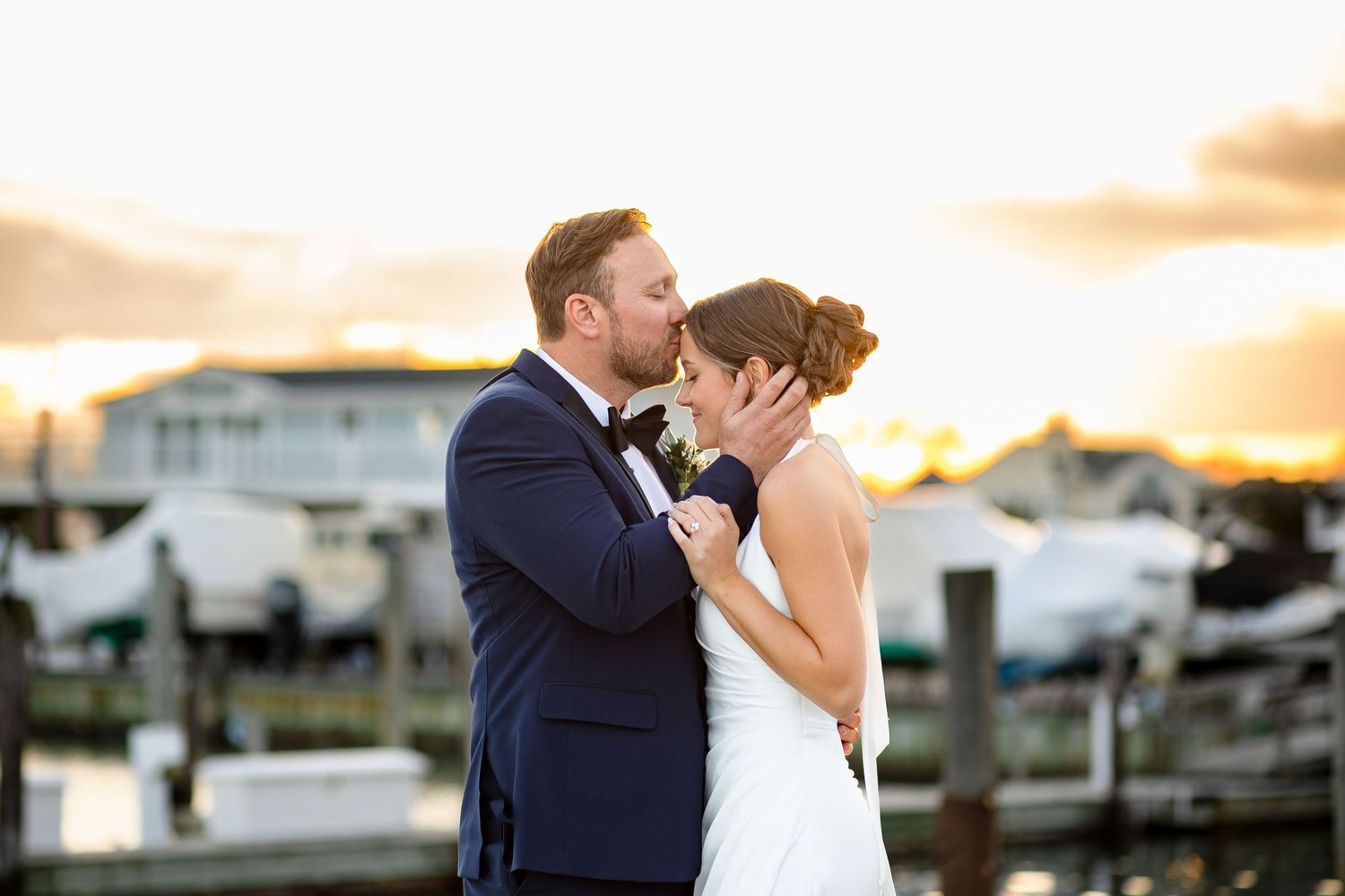 A romantic proposal scene set between rows of grapevines in a scenic vineyard with white flowers and a blanket.