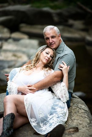 A romantic portrait on rocky riverbank with white lace dress details.