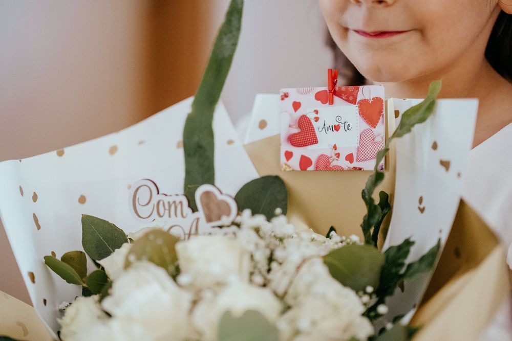 Woman holding a bouquet of white flowers with a romantic love card, perfect for Valentine's Day or a special occasion.