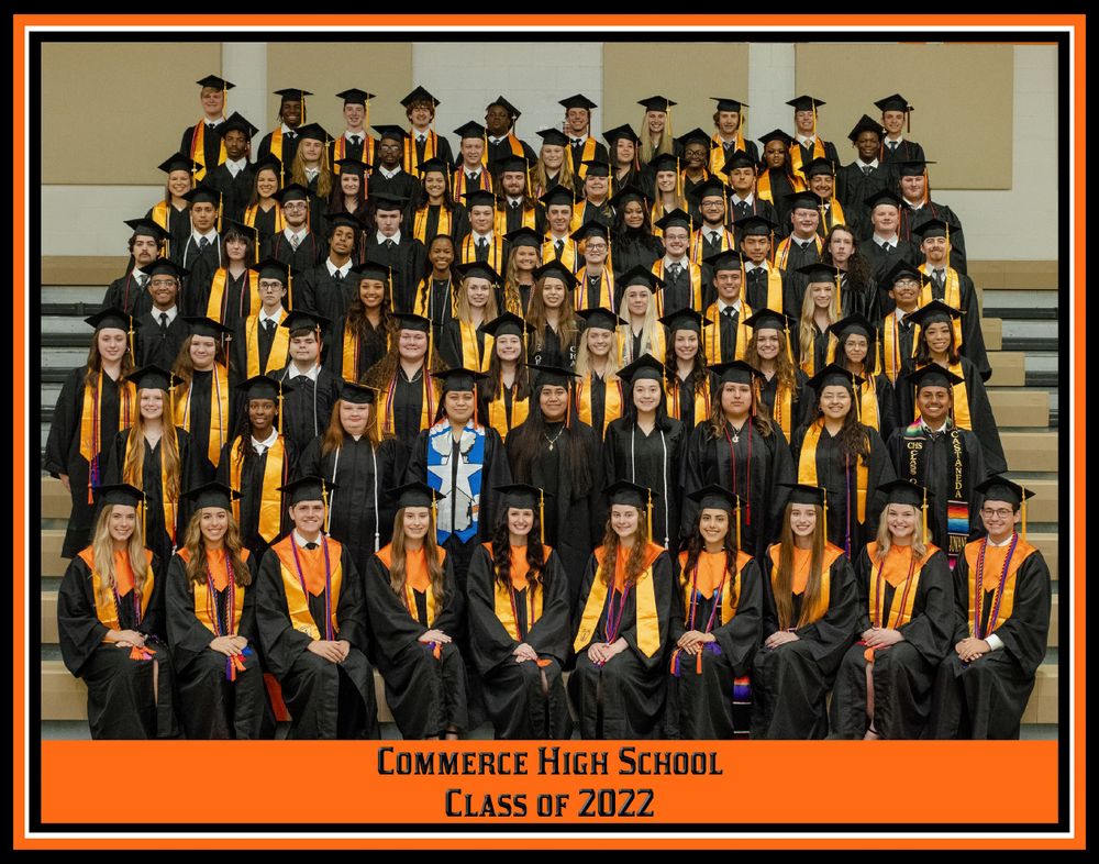 Large graduating class of 2022 from Commerce High School wearing black academic gowns with gold stoles in formal group photo.