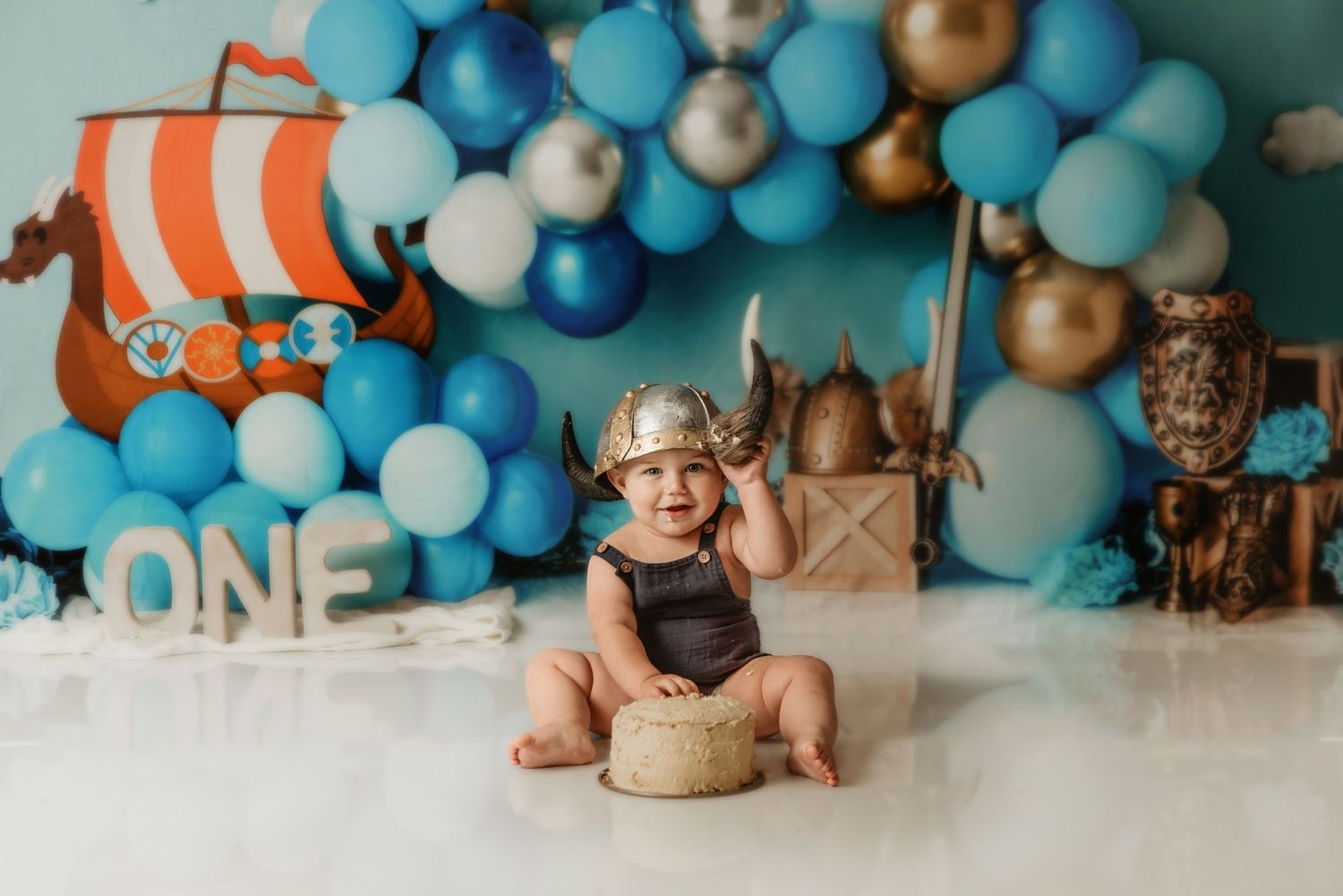 viking theme cakesmash featuring balloon arch, wooden ship decoration and party decor in blue and gold tones. whakatane cakesmash