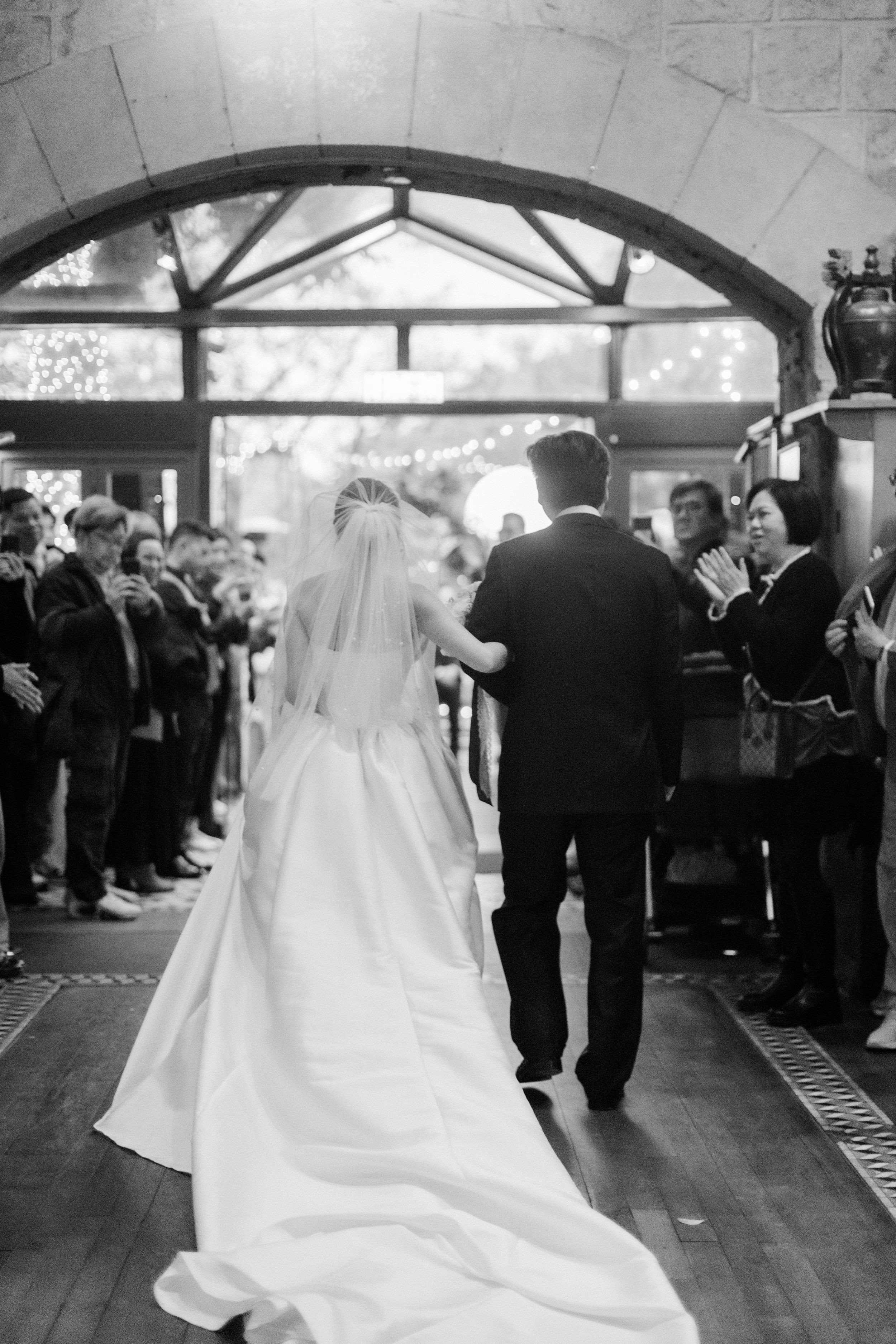 Black and white photo of bride and groom walking down the aisle at their wedding ceremony.