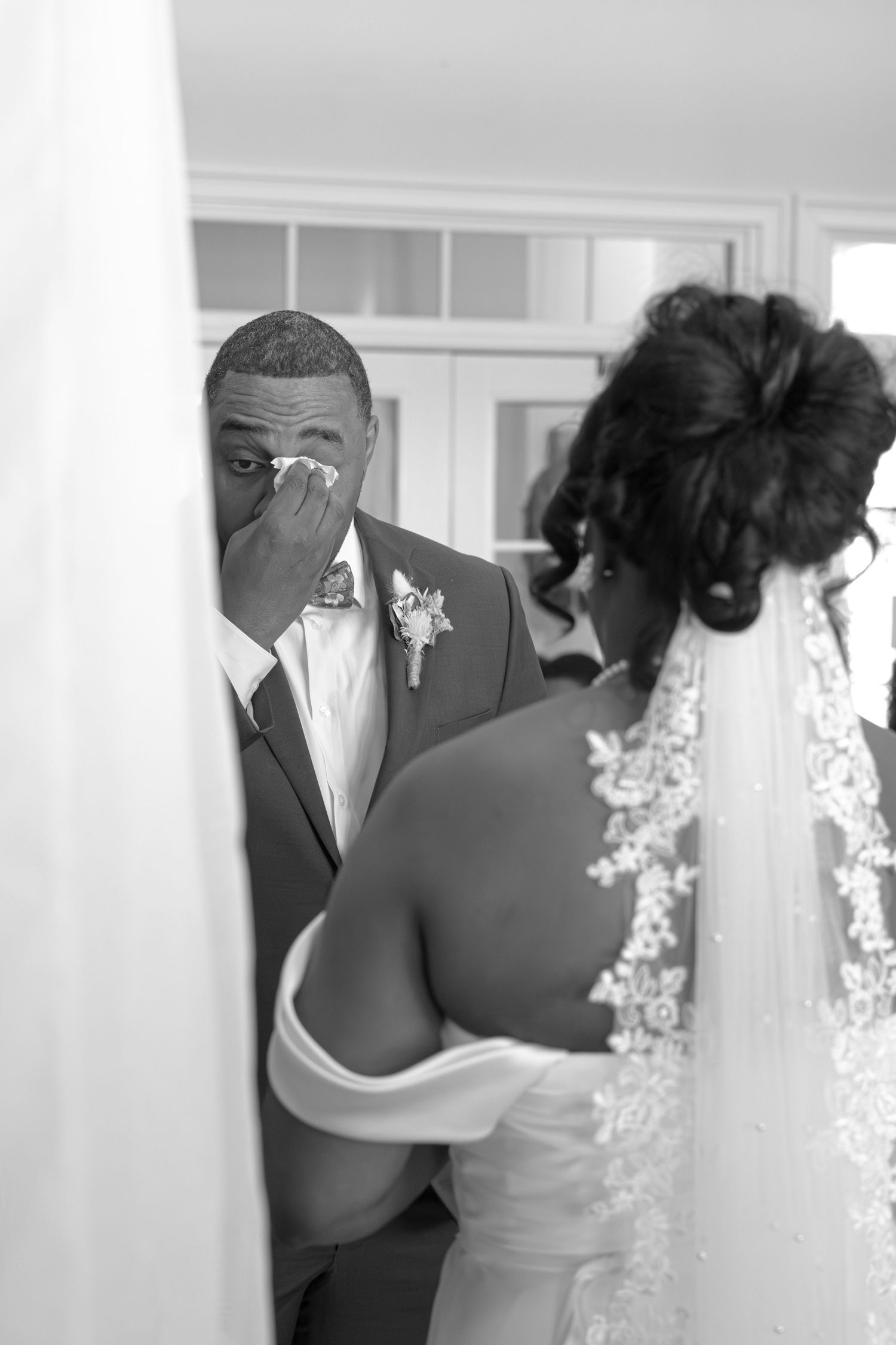 An emotional first look moment captured in black and white during a wedding ceremony.