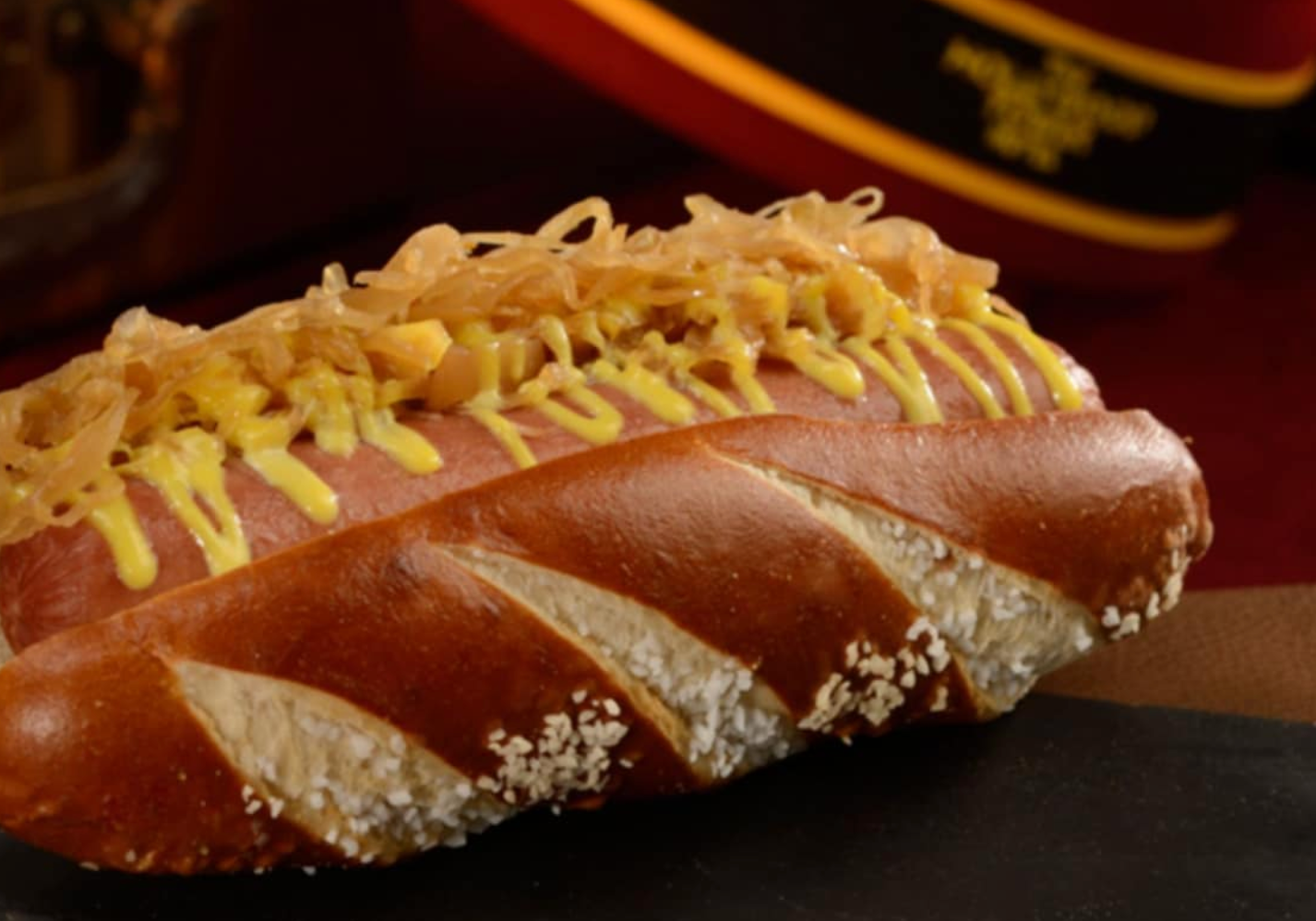 Gourmet hot dog in a pretzel bun topped with yellow mustard.