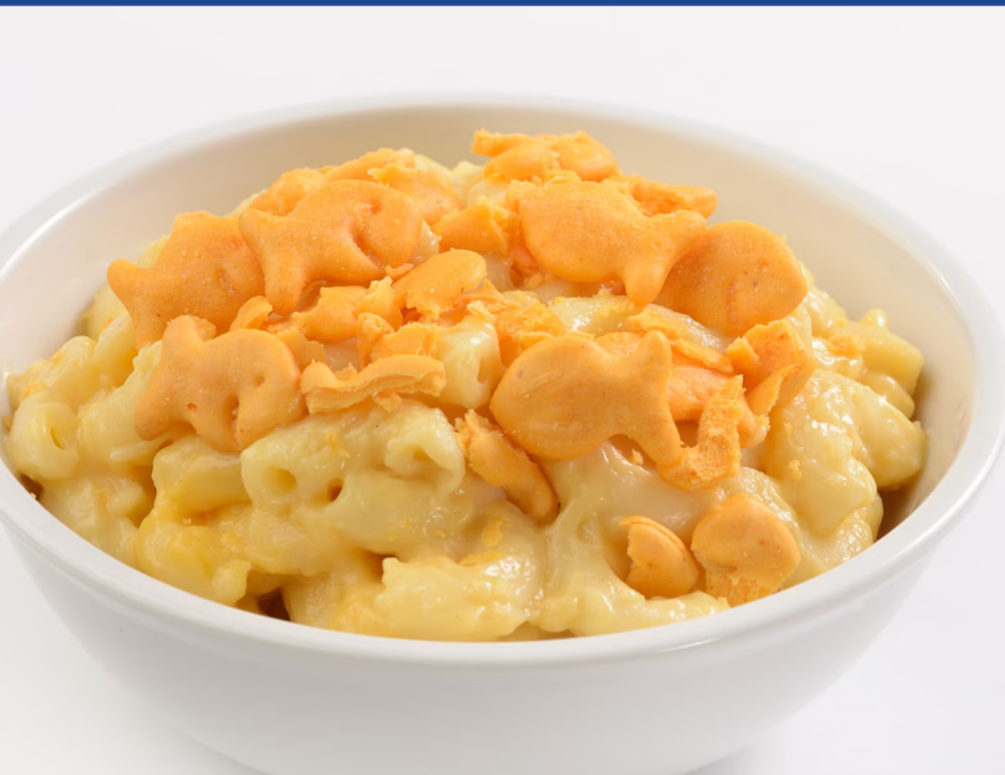 Bowl of creamy mac and cheese topped with melted cheddar cheese.