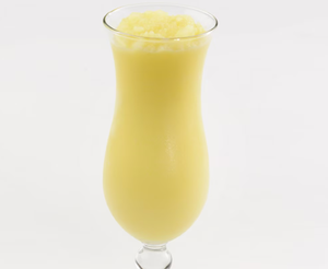 Creamy yellow pina colada smoothie served in a tall hurricane glass.