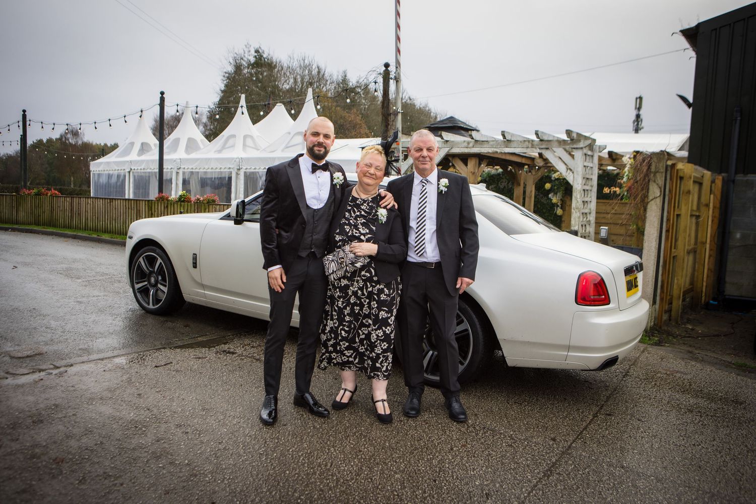Wedding party arriving in white limousines outside a venue.