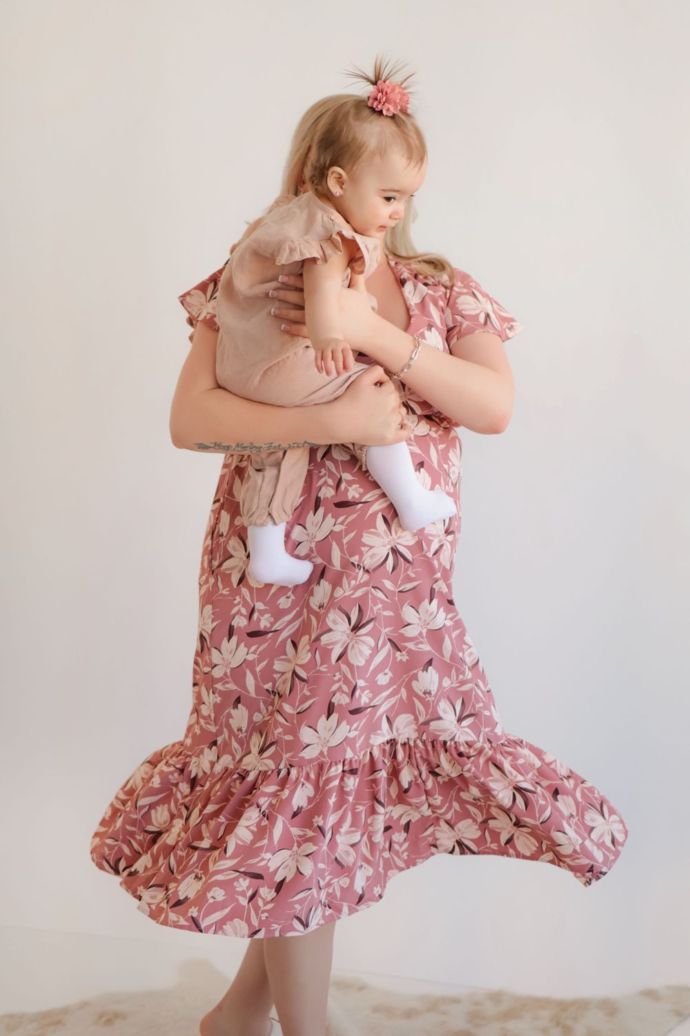 Dancing and twirling moments showcased in a pink floral dress photoshoot.