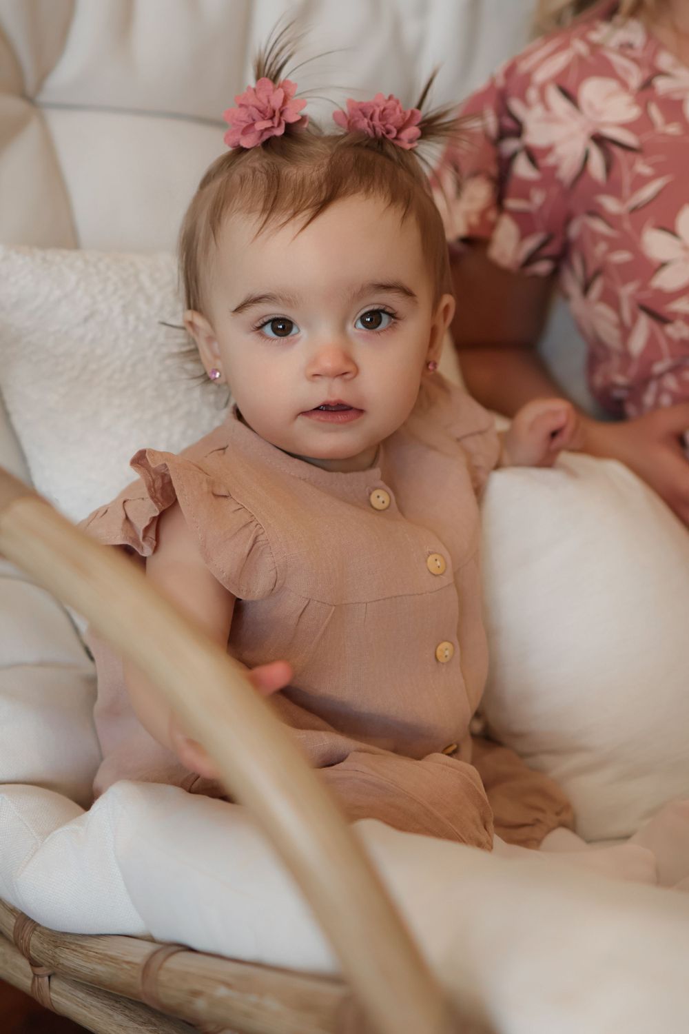 Close-up portrait shots on white bedding featuring a dusty rose colored outfit.