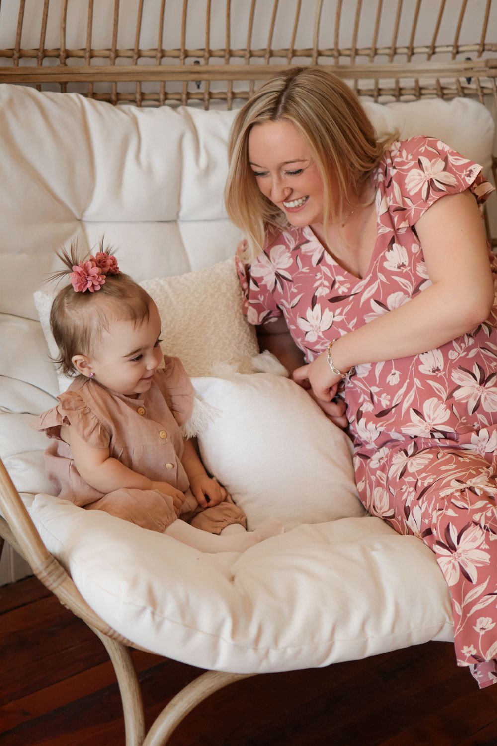 Cozy moments captured on a white cushioned rattan chair with pink floral accents.
