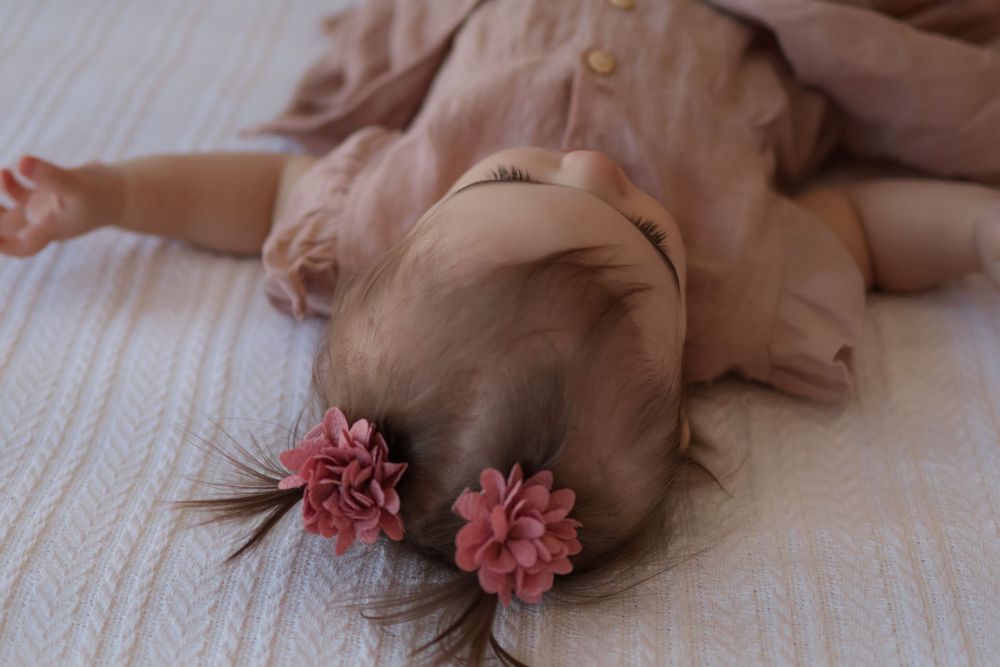 Pink dress with delicate floral details against white background.