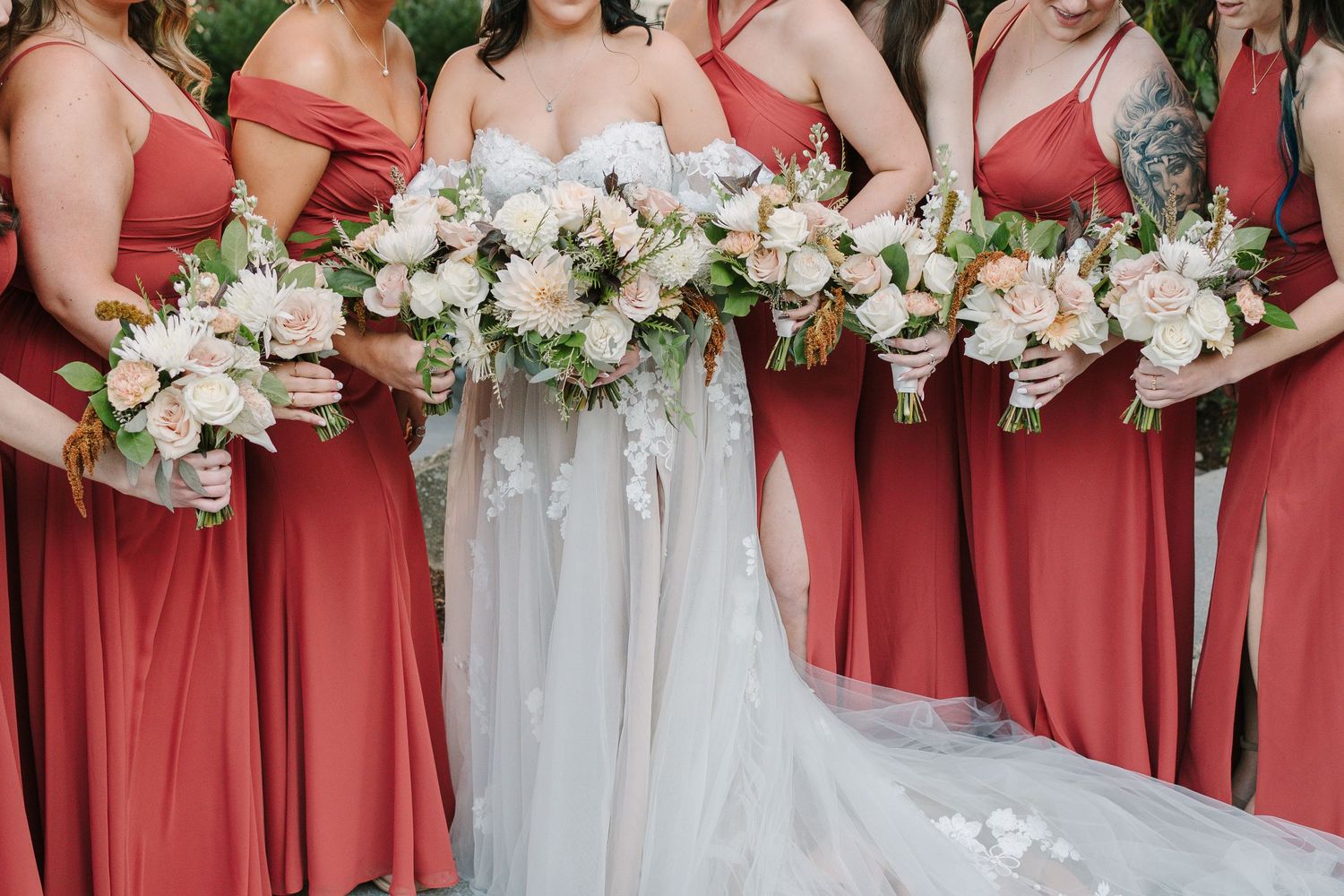 Wedding party photo showing coral bridesmaid dresses and white floral bouquets.