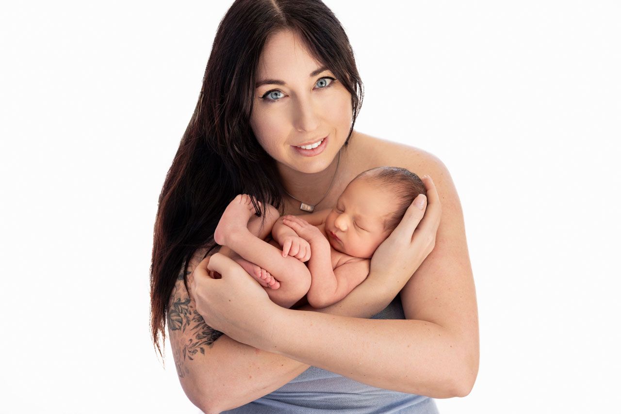 kin‑to‑skin connection – mum holding newborn against her chest, with a baby blue wrap
