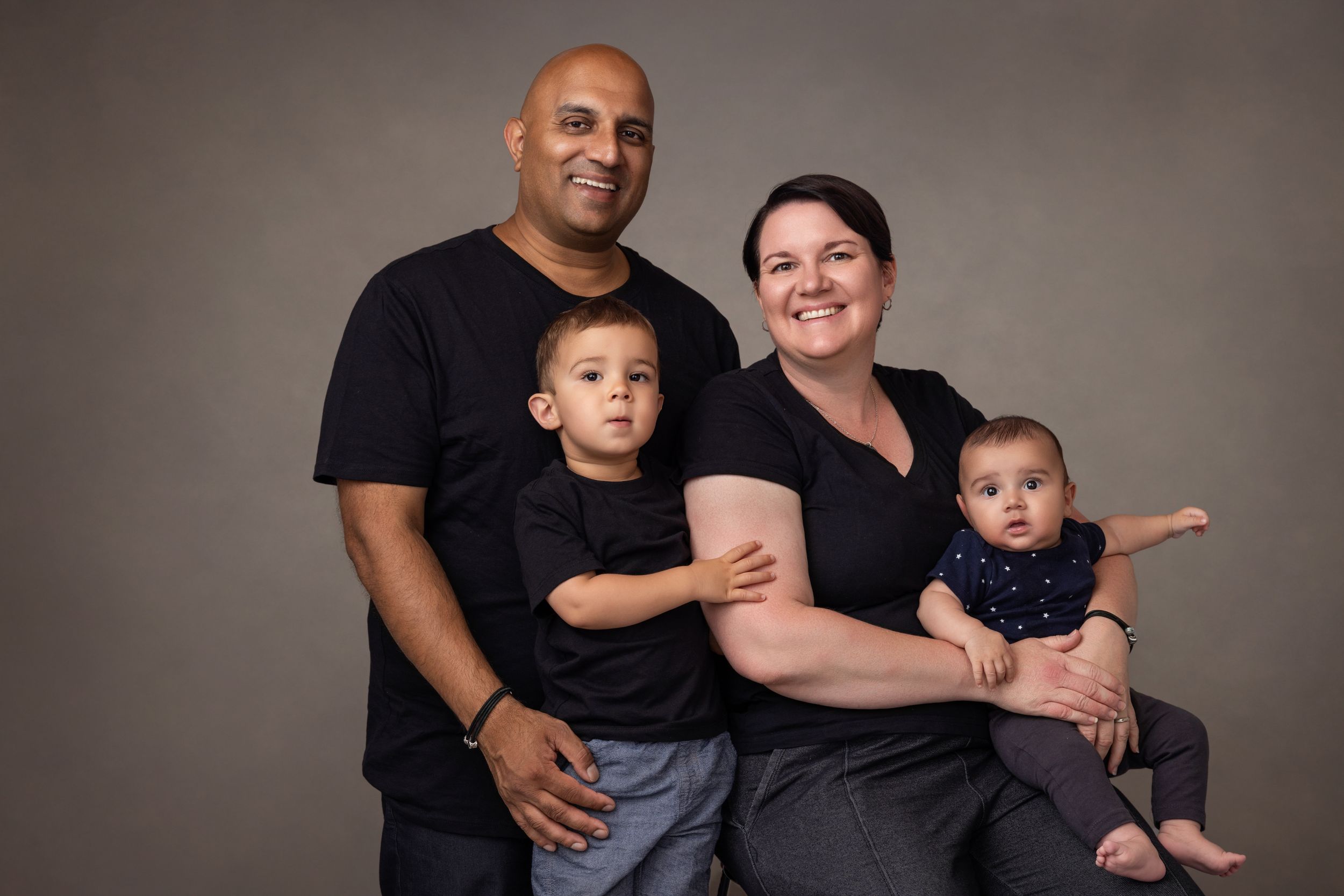 A family of four come in close for a contemporary family portrait.