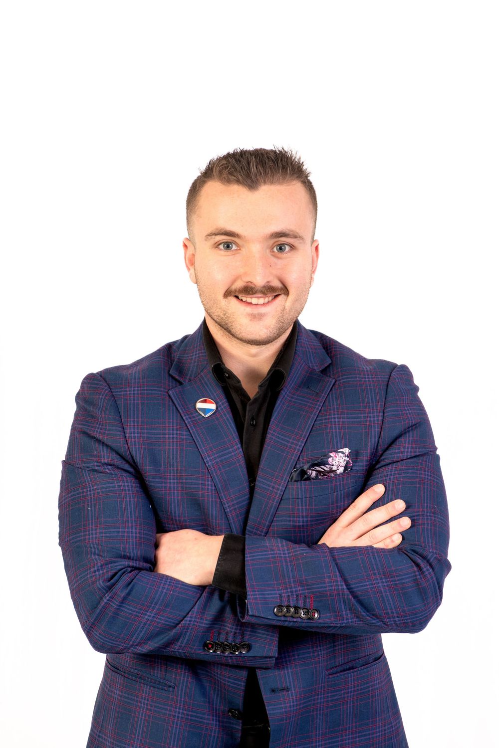 Professional wearing a navy plaid blazer and black shirt poses with crossed arms in three similar headshots.