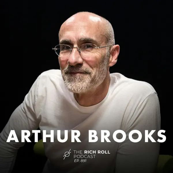 Portrait of a person with glasses and white beard wearing a white t-shirt against dark background with text overlay.