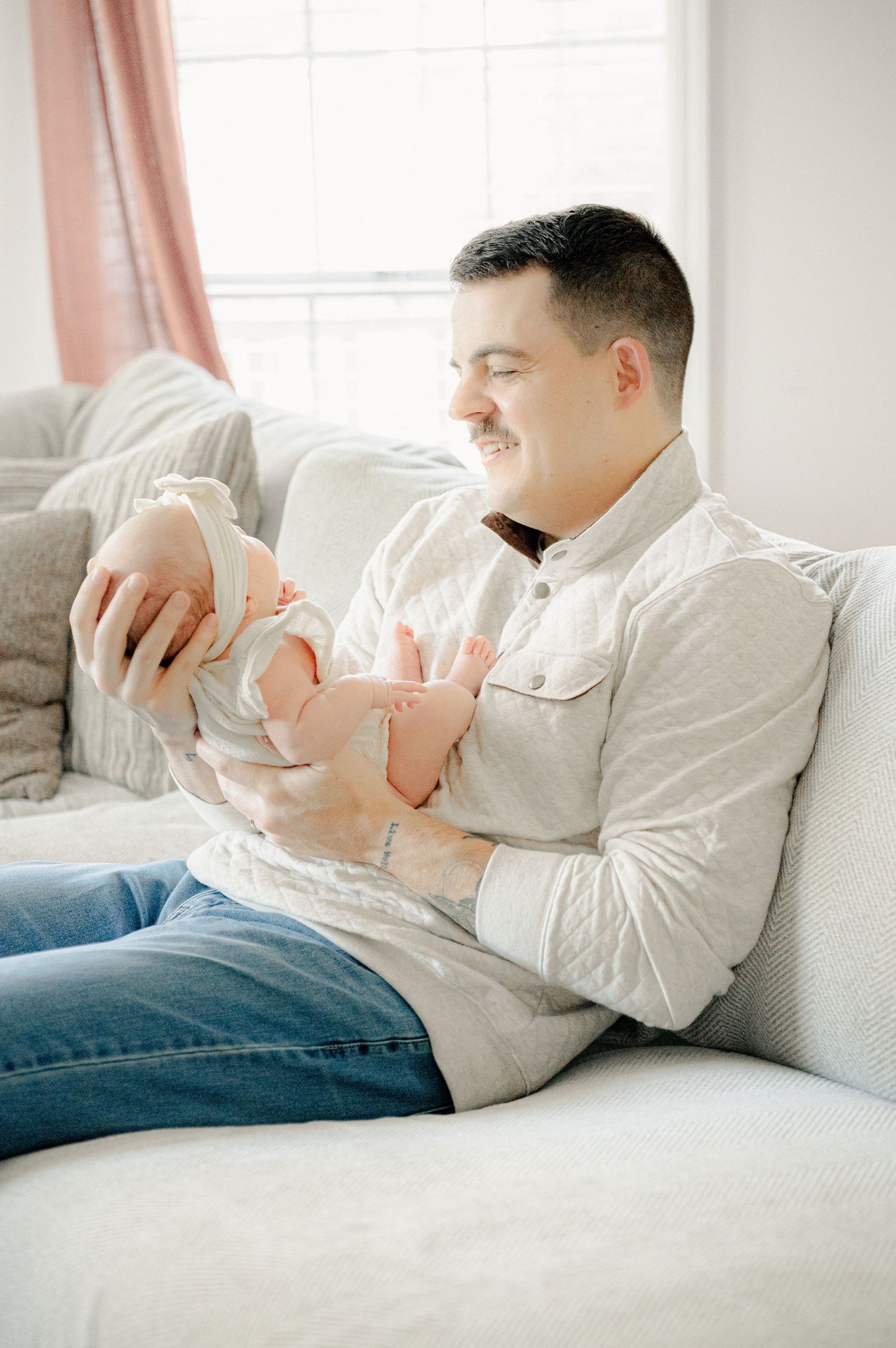 Peaceful moment on a white couch with a newborn baby.