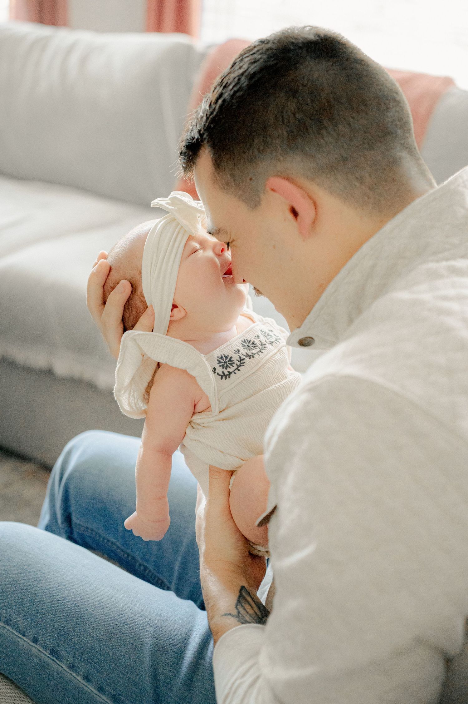 A tender moment captured between parent and infant in soft natural light.