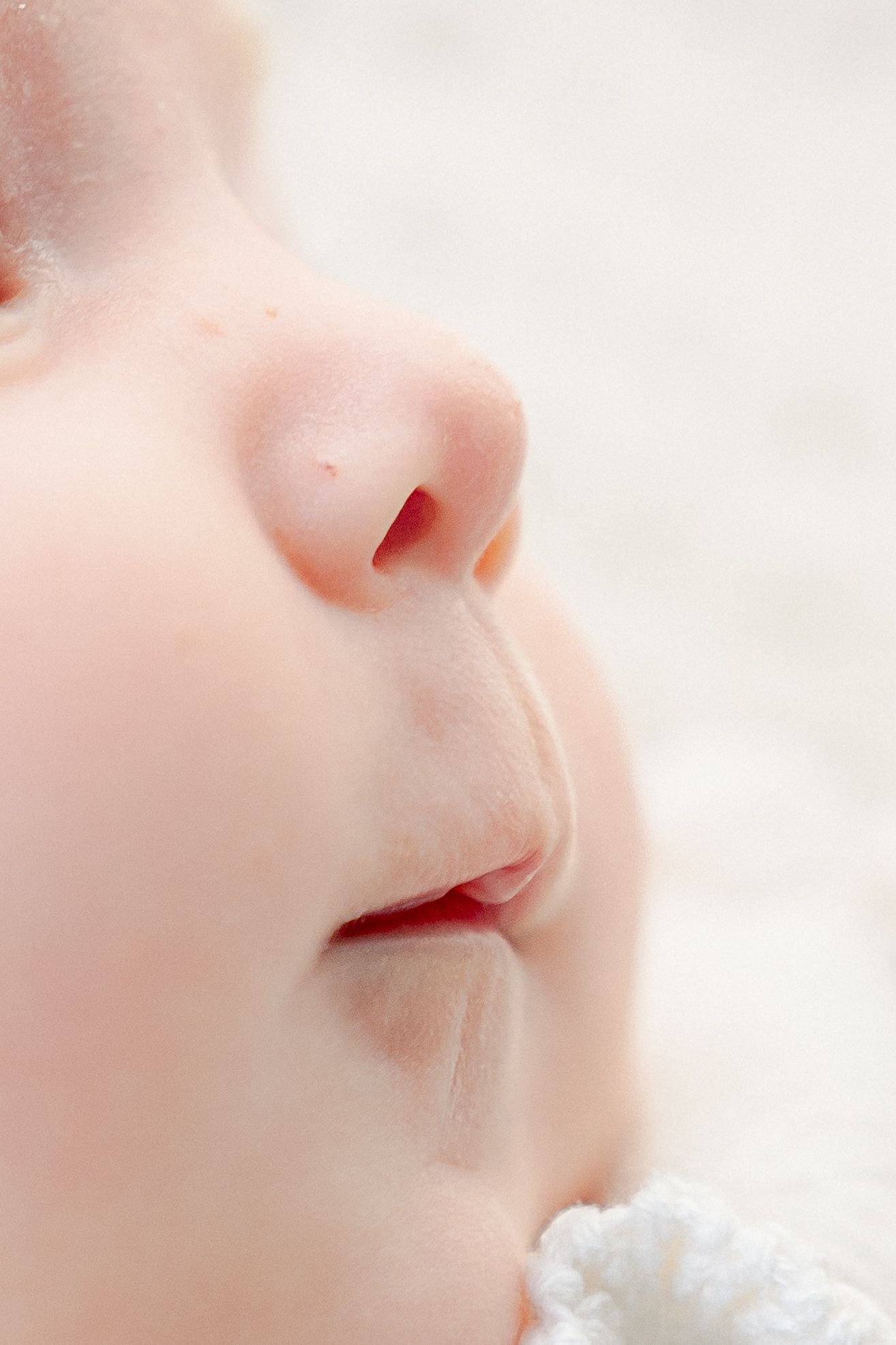 Extreme close-up of a baby's delicate features in soft lighting.