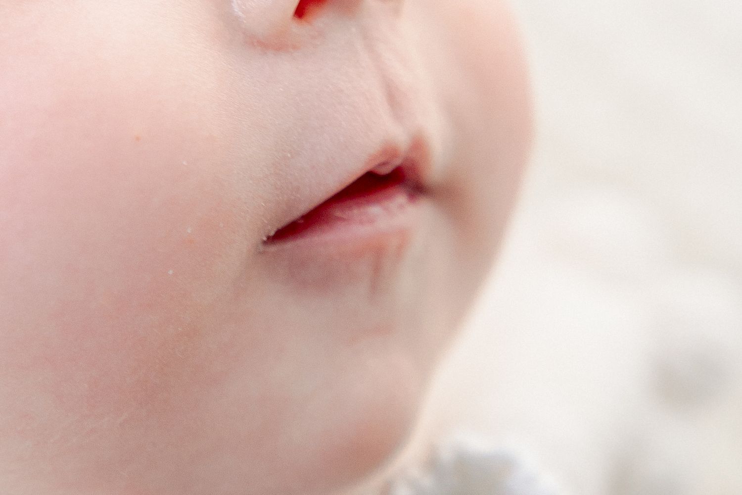 Close-up portrait of a baby's lips and nose with soft focus.