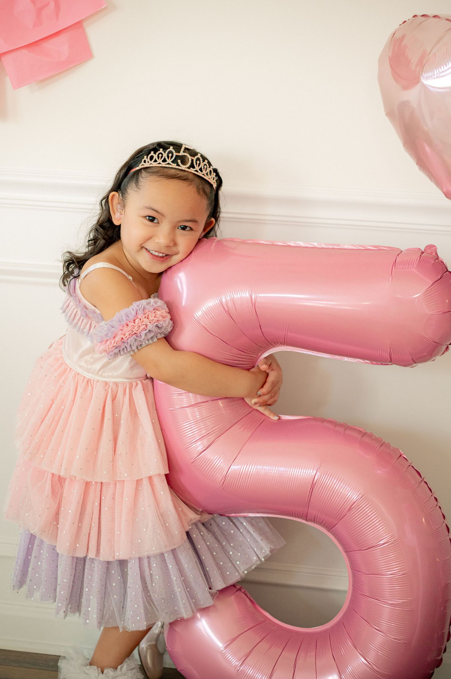 A princess-themed celebration with a large pink number balloon and tulle dress.