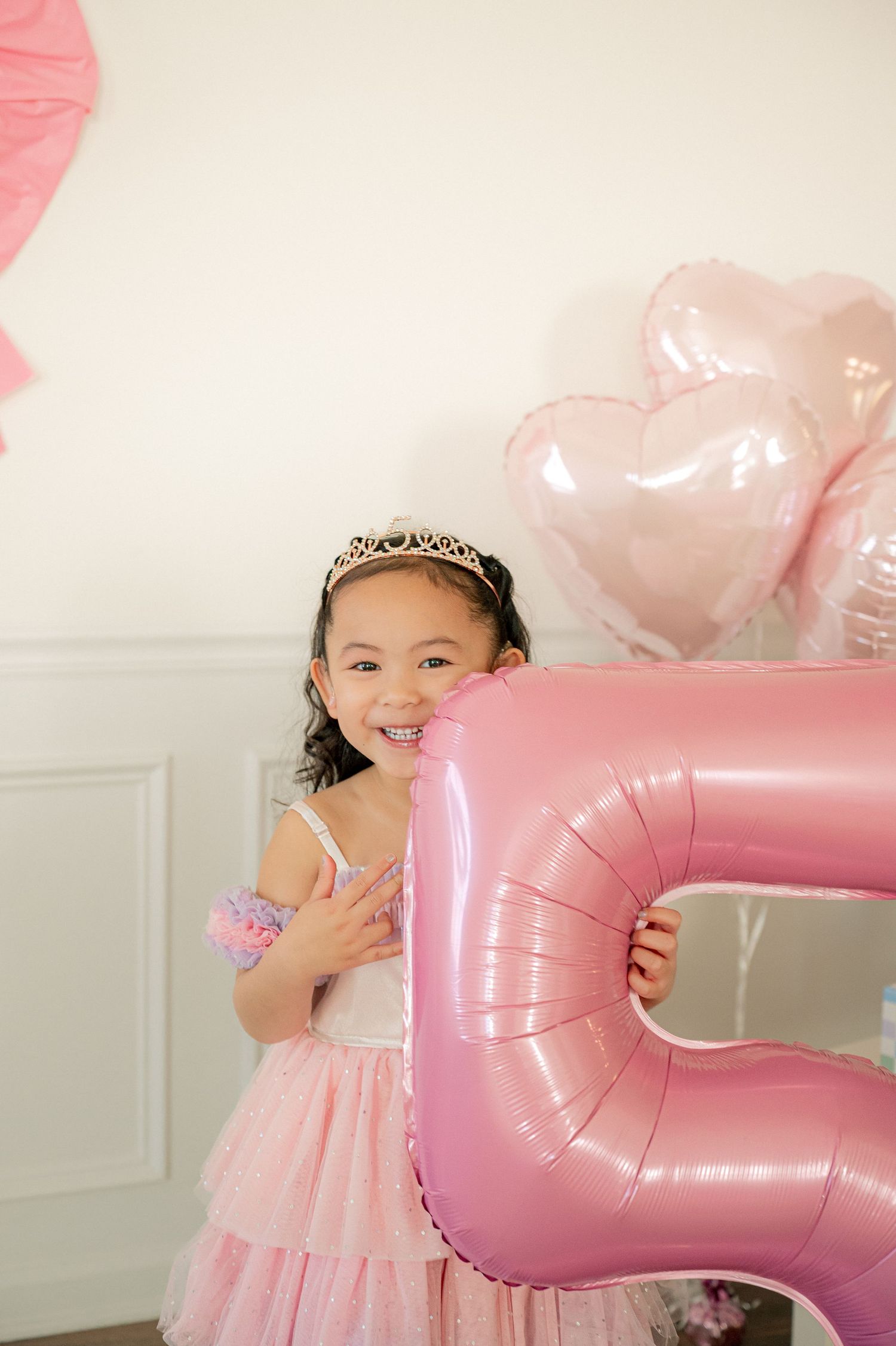 A birthday celebration scene with pink balloons and party decorations.