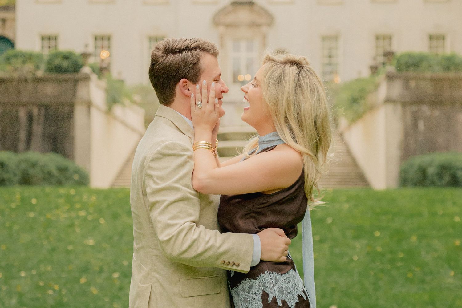 Romantic couple sharing intimate moments in a garden setting with elegant architecture.