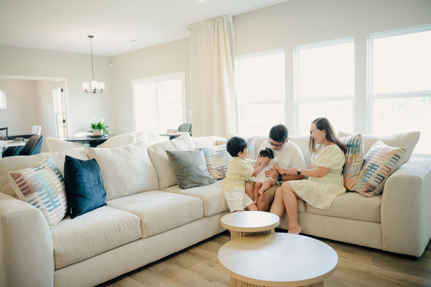 Bright modern living room with white sectional sofa and natural light streaming through windows.