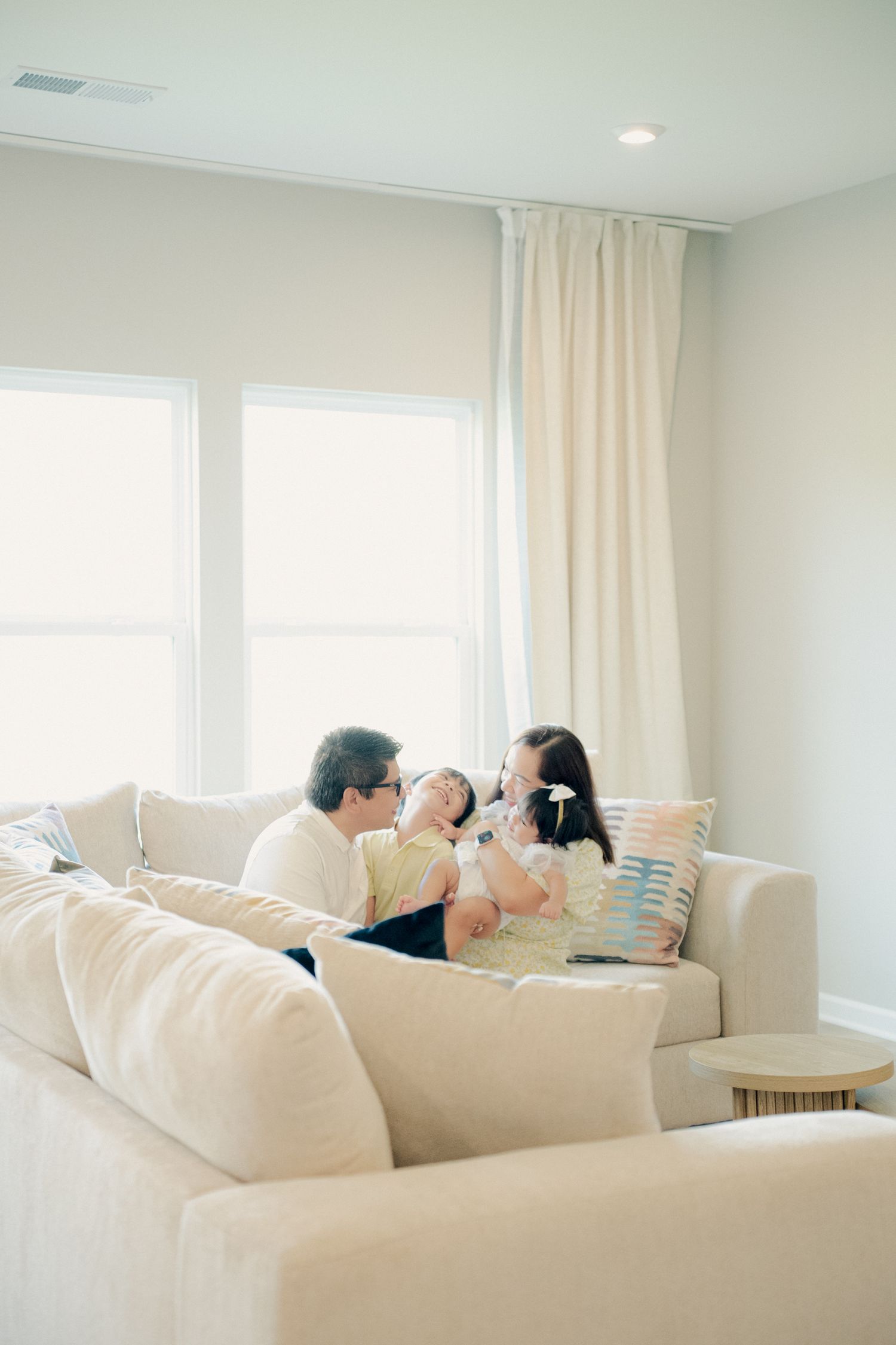 Casual family moment captured on a comfortable white sectional couch in bright interior.