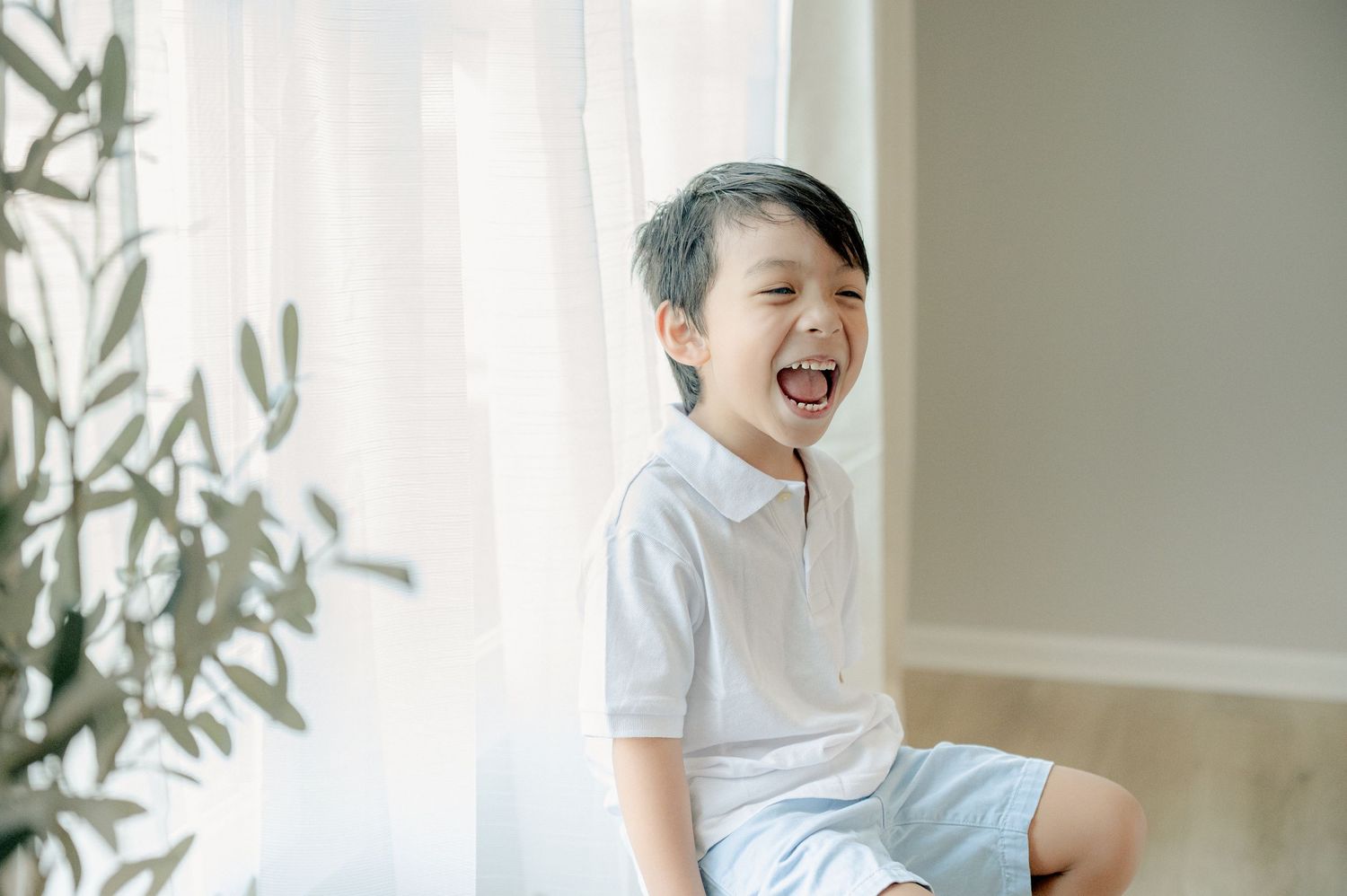 Intimate family photoshoot showing joyful interactions in a minimalist white setting.