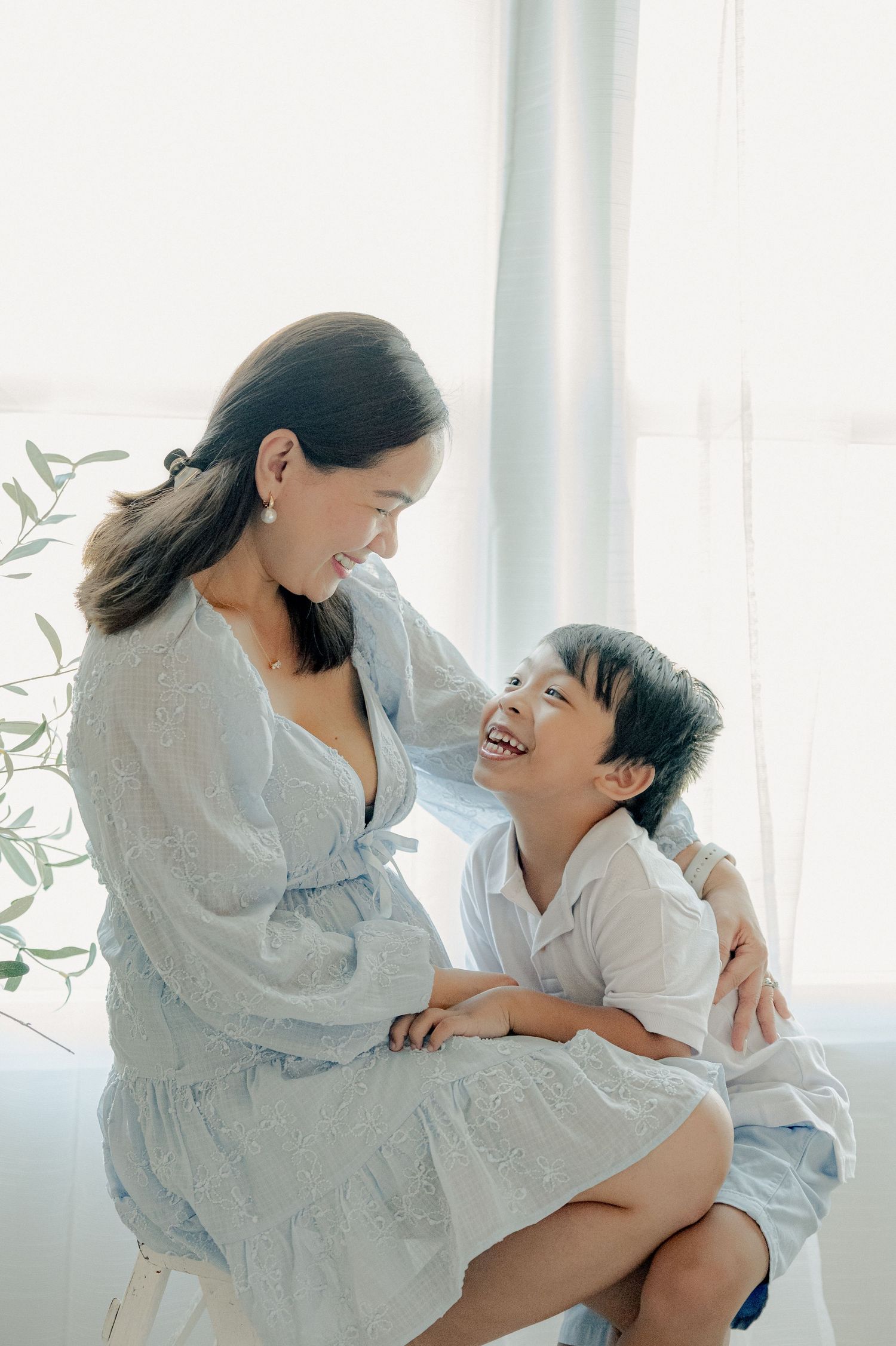 Sweet candid moments between parent and child in white room with natural lighting.