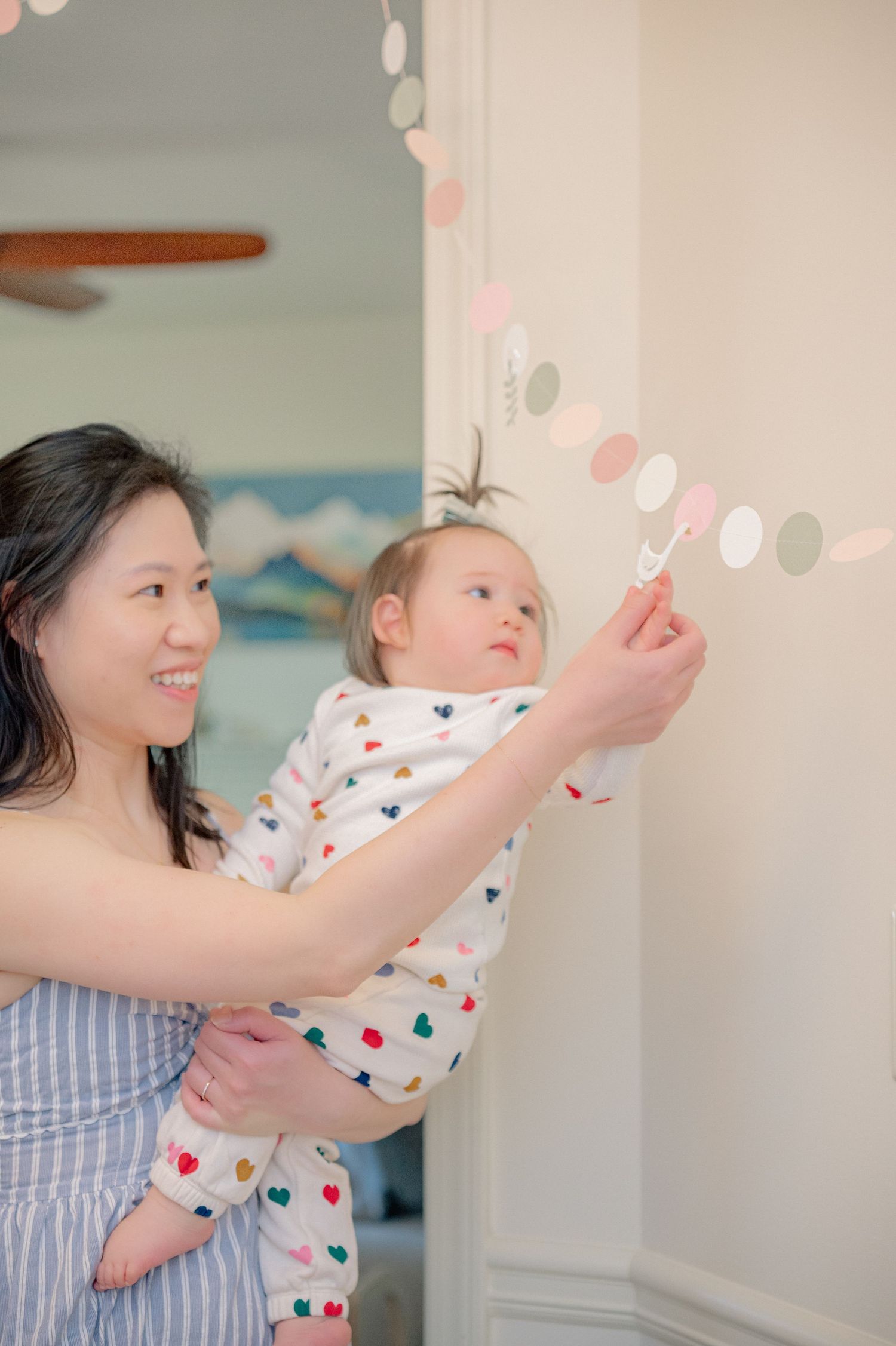 Playful moment with balloons and decorations in a bright, airy room.
